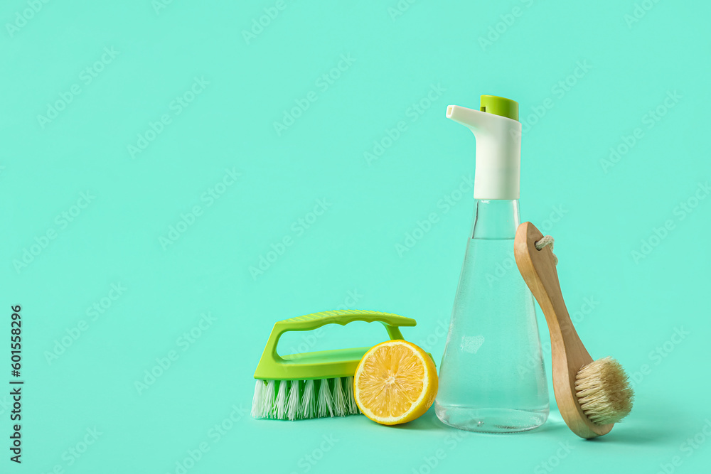 Bottle of vinegar, brushes and lemon on color background