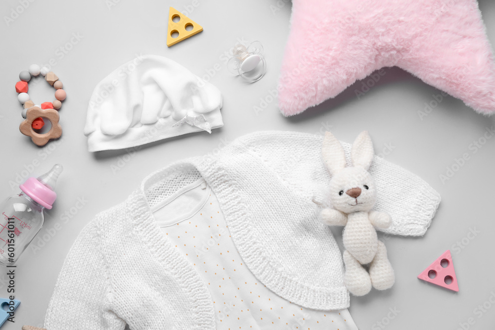 Composition with baby clothes, toys and accessories on grey background