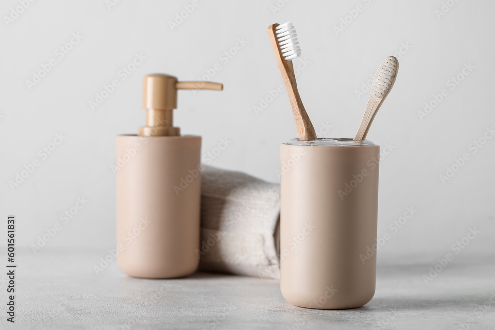 Holder of bamboo toothbrushes and bath accessories on white table