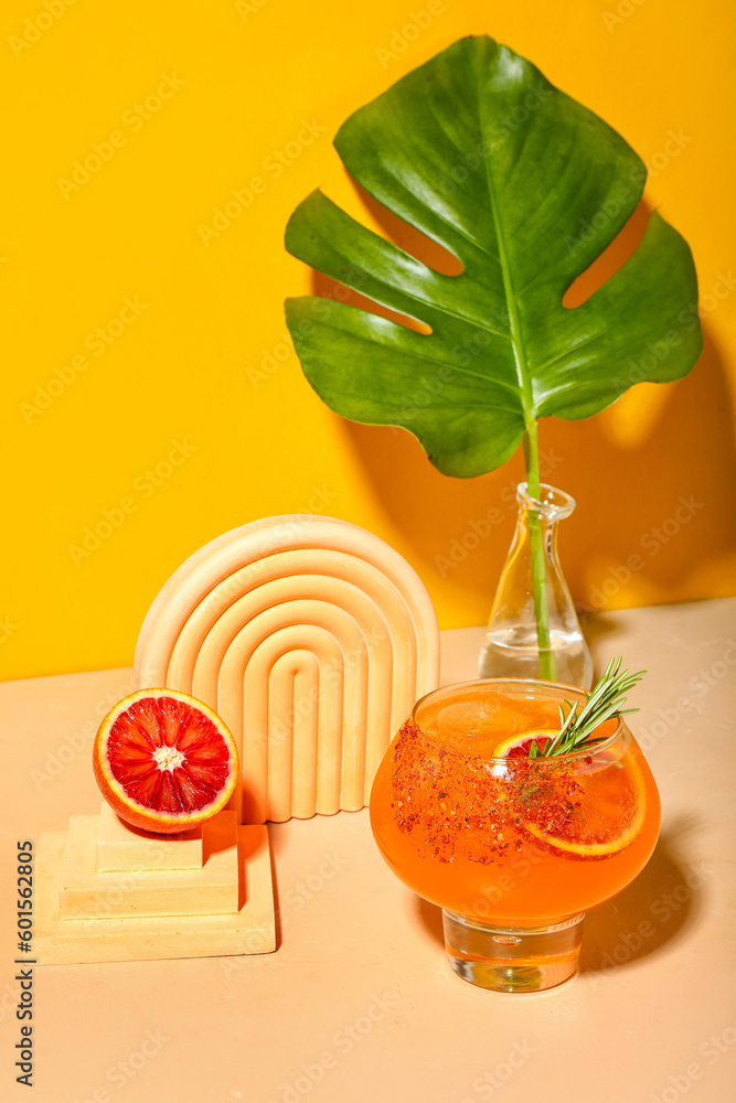 Fresh summer cocktail with grapefruit and rosemary on orange background