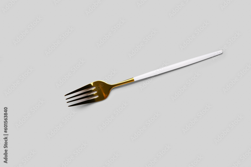 Stainless steel fork with plastic handle on grey background