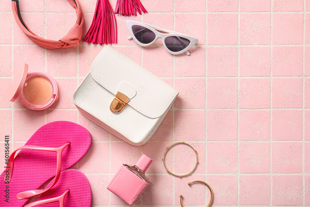 Stylish bag and different accessories on pink tile background