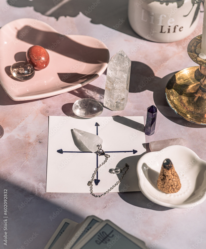 Gemstones for esoteric spiritual practice. Rock crystal pendulum on the table. Divination with a pen