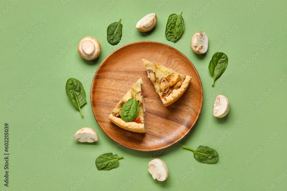 Pieces of mushroom pie with spinach leaves and champignons on green background