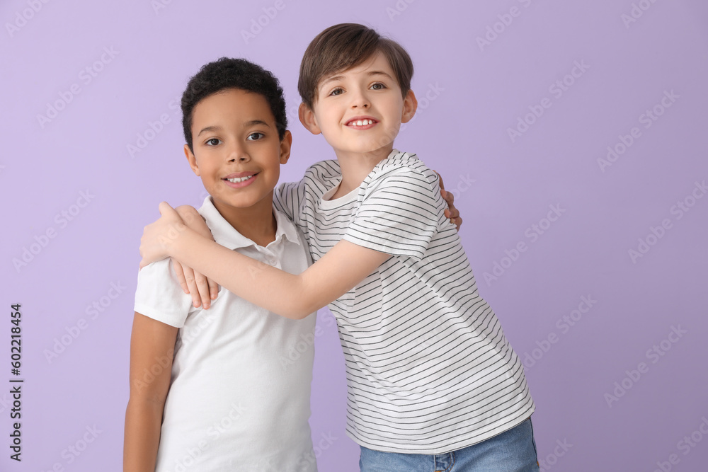 Cute little boys hugging on lilac background