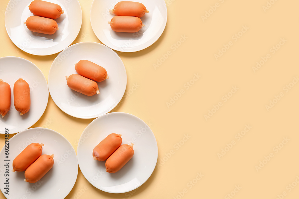 Plates of tasty boiled sausages on beige background