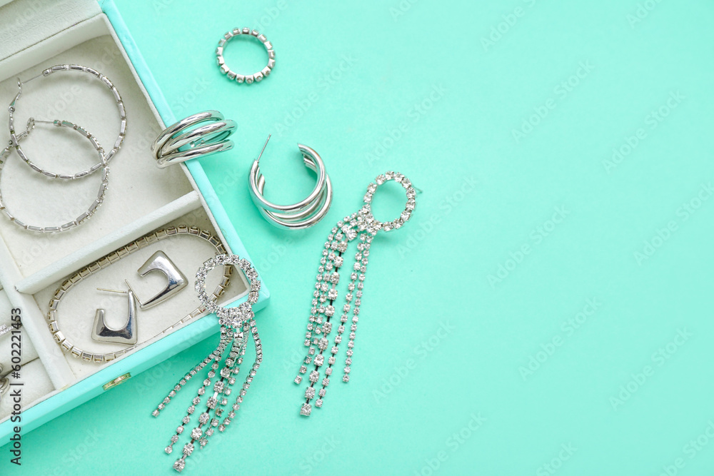 Organizer with stylish jewelry on turquoise background