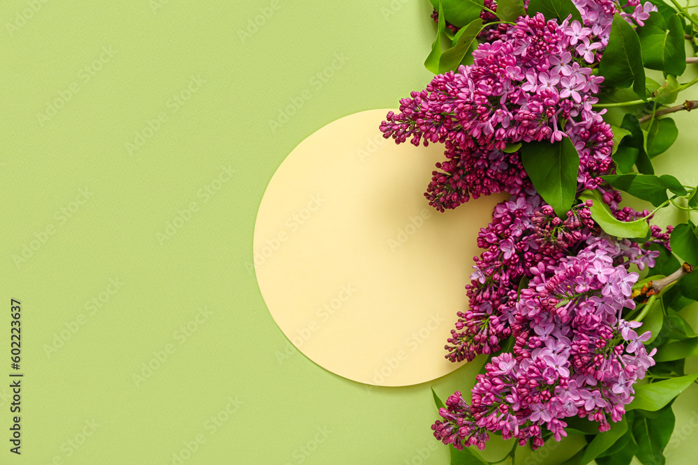 Blank card and beautiful lilac flowers on pale green background