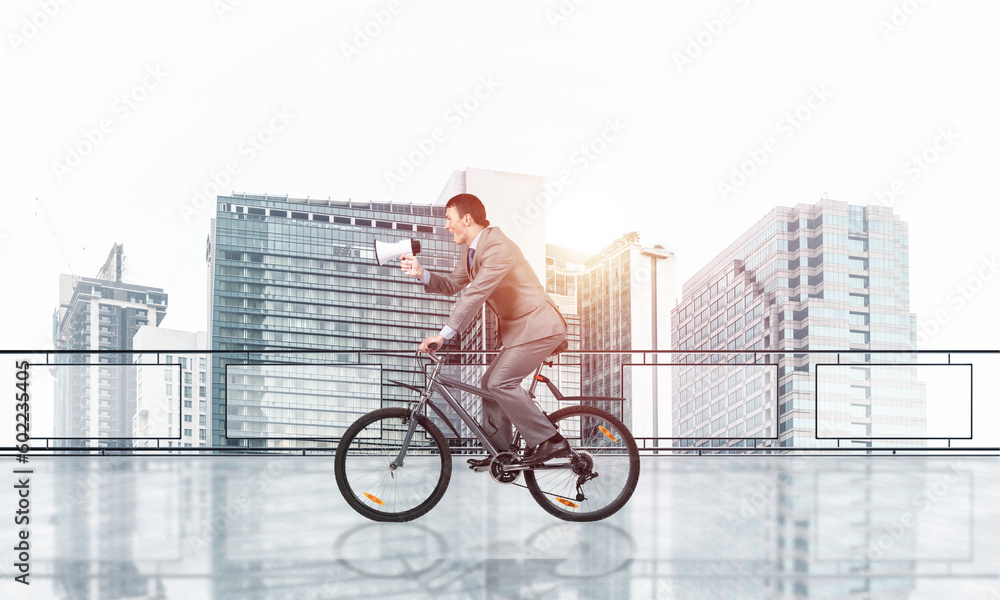 Businessman with megaphone in hand on bike