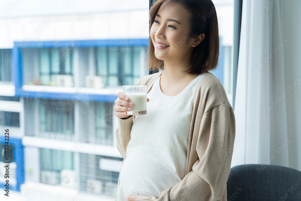 Portrait of young Asian pregnant with milk looking outside at home