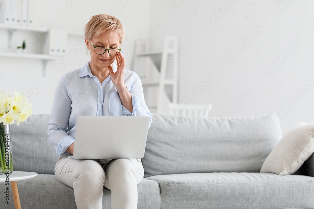 Mature psychologist working with laptop in office