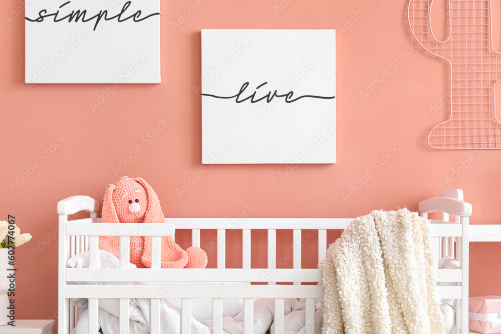 Baby crib with toy bunny in stylish bedroom