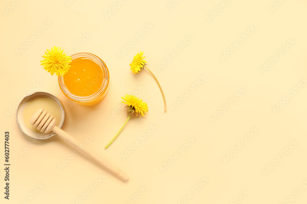 Jar with dandelion honey on beige background