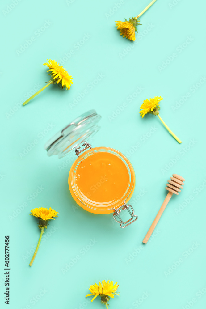 Jar with dandelion honey on turquoise background