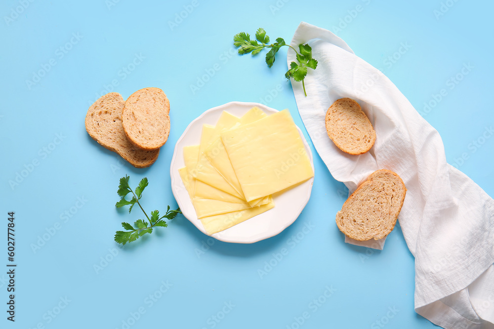 Plate of tasty processed cheese with bread on blue background