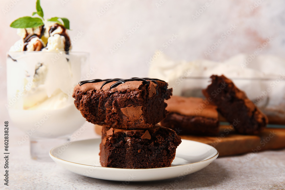 Plate with pieces of tasty chocolate brownie on light background