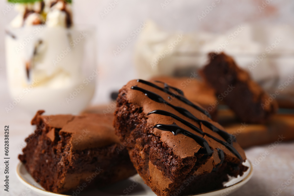 Plate with pieces of tasty chocolate brownie on table, closeup