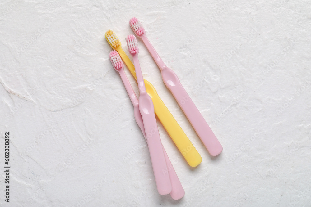 Plastic toothbrushes on white textured background