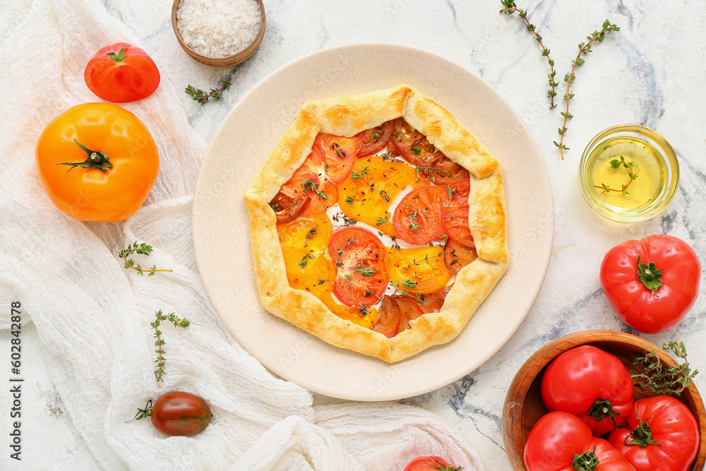 Plate with tasty tomato galette on white background