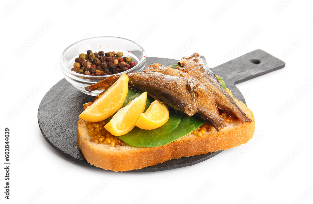 Slate board of tasty sandwich with canned smoked sprats on white background