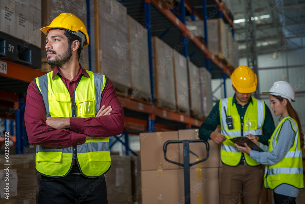 Logistics worker storing package boxes in a large distribution centre,Warehouse worker moving cardbo