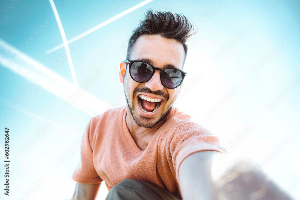 Handsome young man taking selfie with smart mobile phone outside - Cheerful guy smiling at camera - 