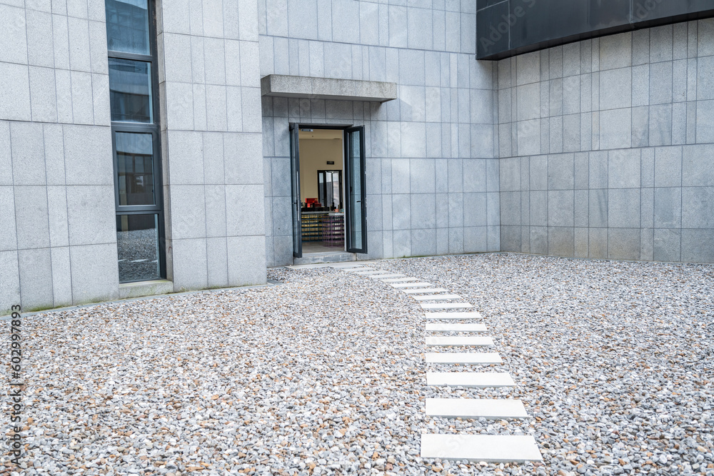 Empty mirror of granite wall and gravel ground