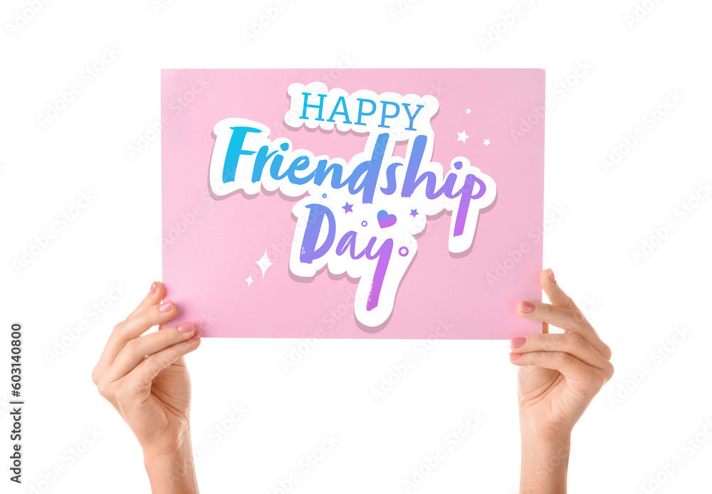 Female hands holding paper with text HAPPY FRIENDSHIP DAY on white background