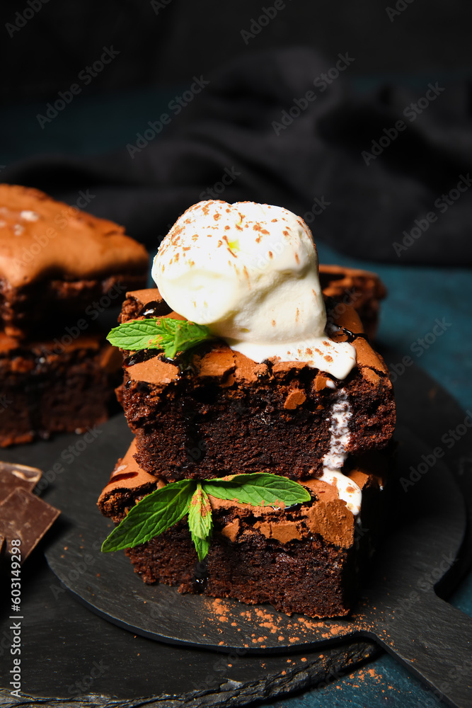 Boards with pieces of tasty chocolate brownie and ice cream on dark background