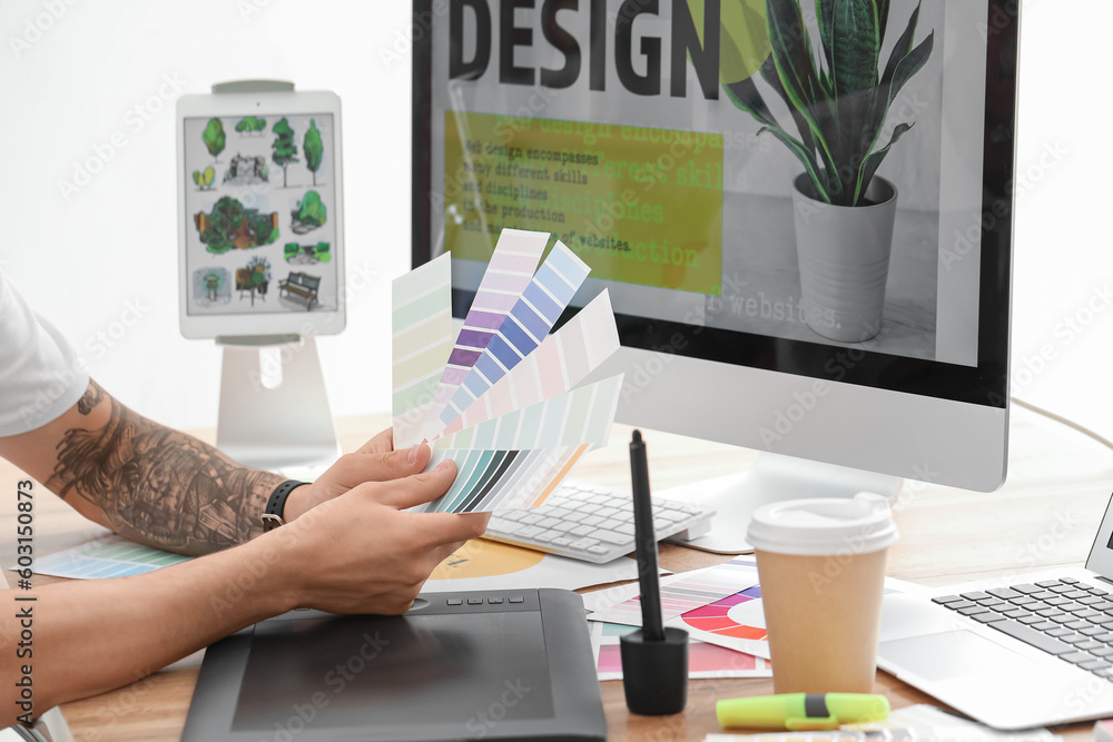 Male graphic designer working with color palettes in office, closeup