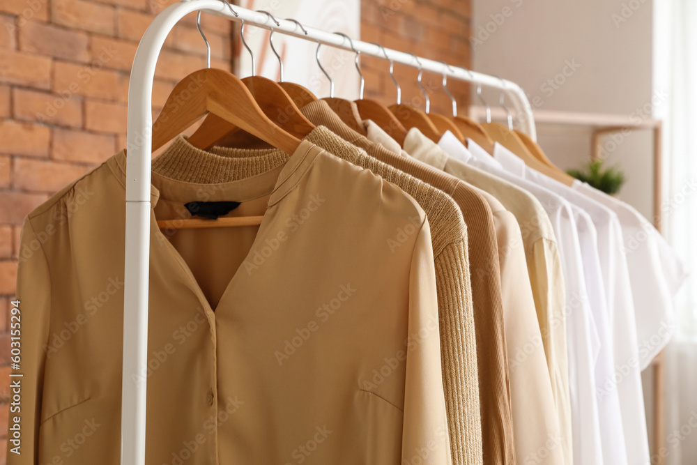 Rack with stylish female clothes in boutique, closeup