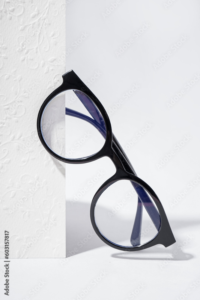 Modern black eyeglasses on white background