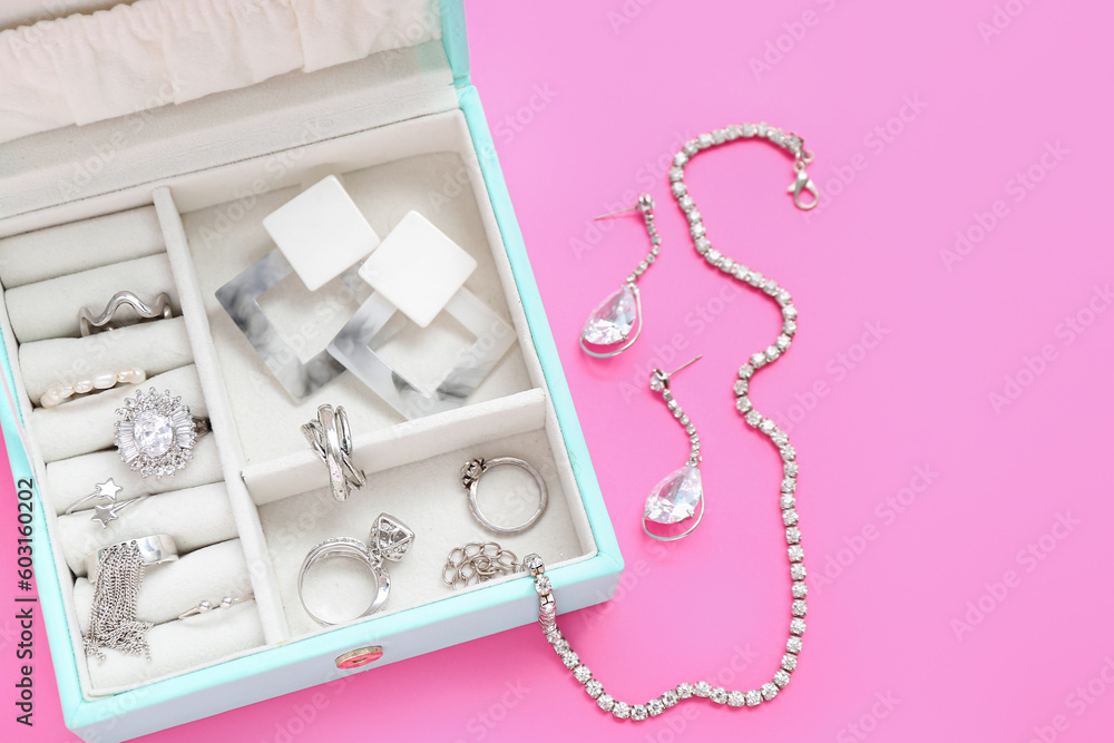 Organizer with stylish jewelry on pink background