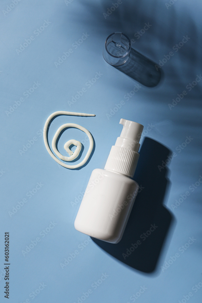 Bottle of sunscreen cream on blue background