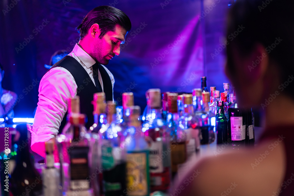 Caucasian profession bartender making a cocktail for women at a bar.