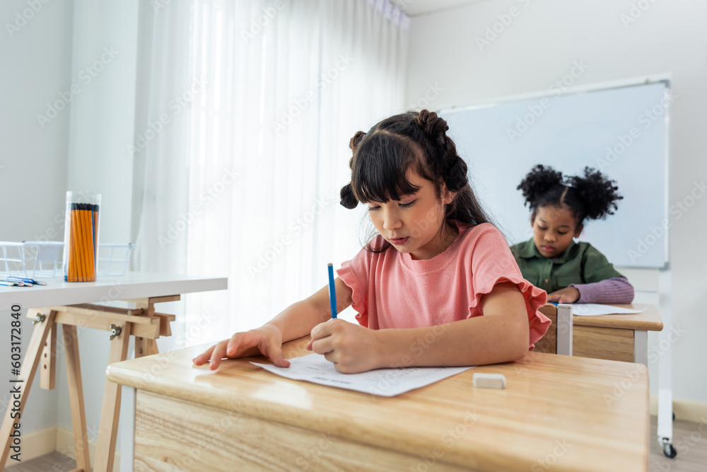 Caucasian young girl student doing an exam test at elementary school.