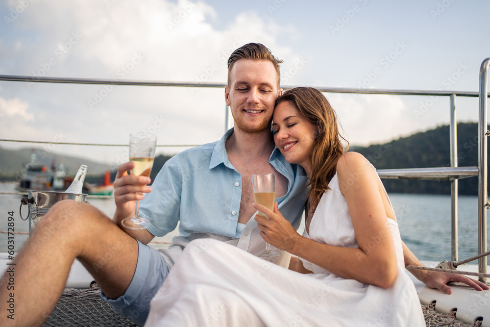 Caucasian young couple drinking champagne while having party in yacht.