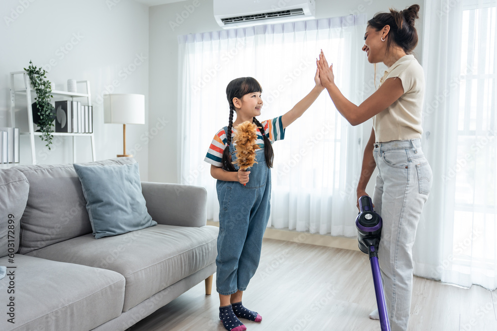 Caucasian beautiful mother cleaning house with young kid daughter.