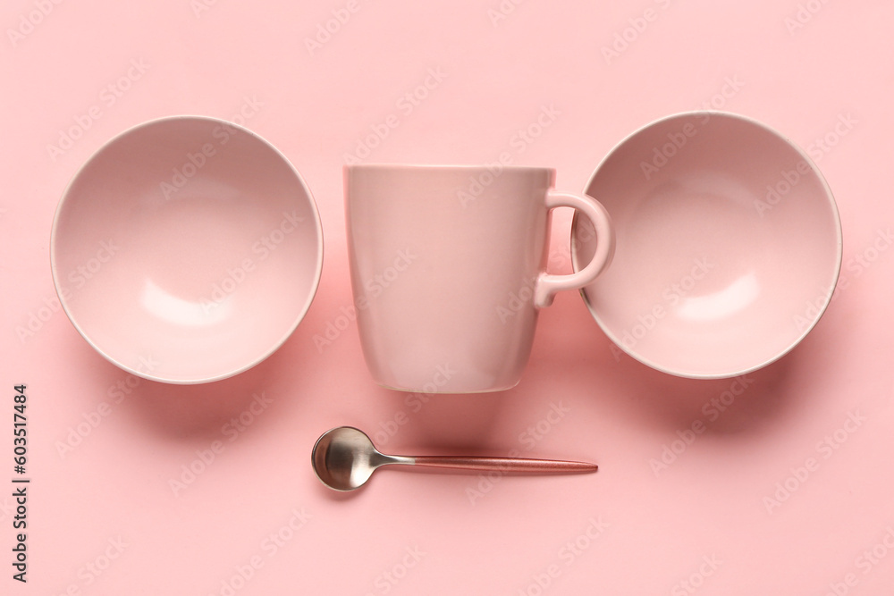 Composition with clean bowls, cup and spoon on pink background