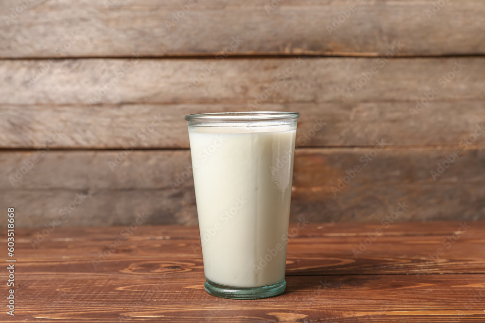 Glass of fresh milk on wooden background