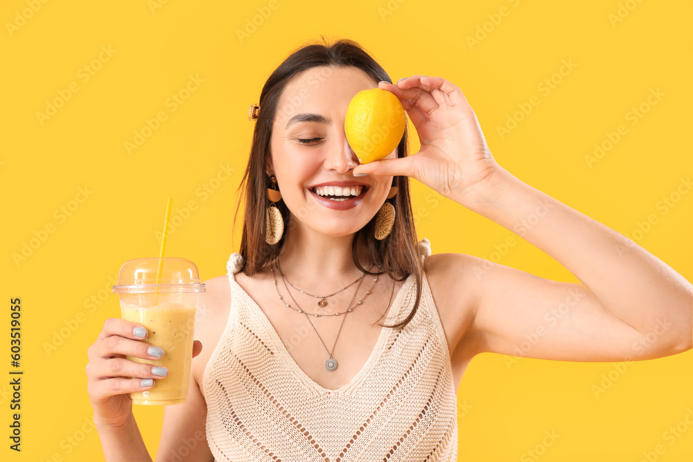 Young woman with glass of smoothie and lemon on yellow background, closeup