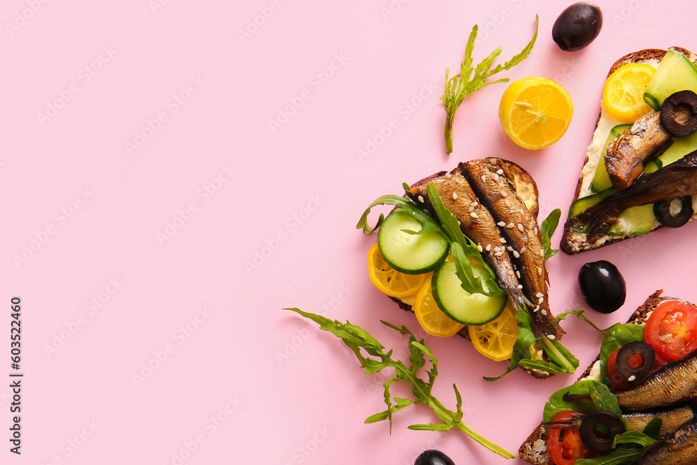 Tasty sandwiches with canned smoked sprats on pink background