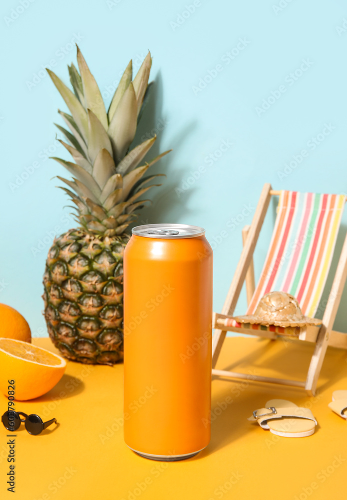 Can of soda with beach decor and fruits on table near blue wall