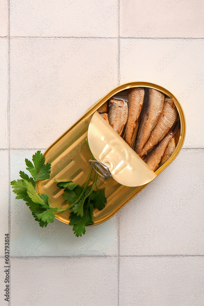 Canned smoked sprats with parsley on white tile background