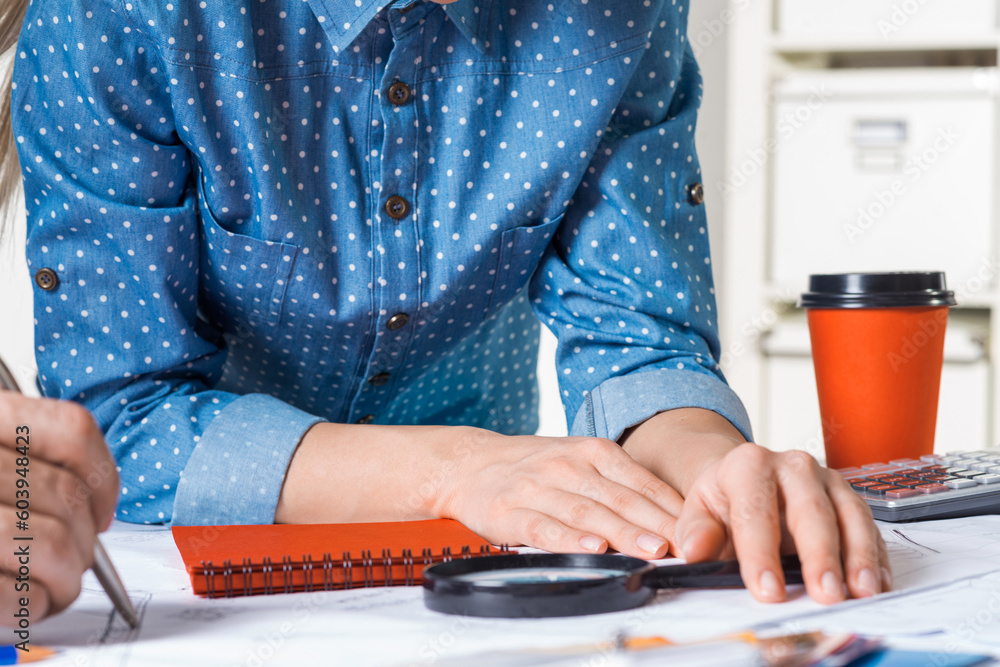 Architect standing near desk with blueprints