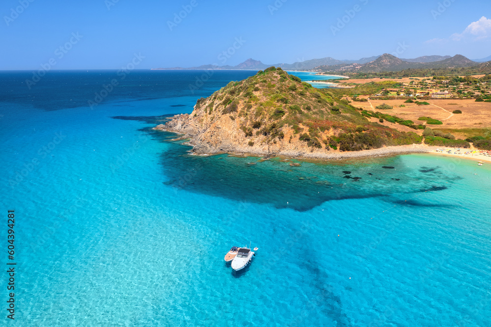 Aerial view of luxury yachts on blue sea at sunset in summer. Sardinia, Italy. Tropical seascape wit