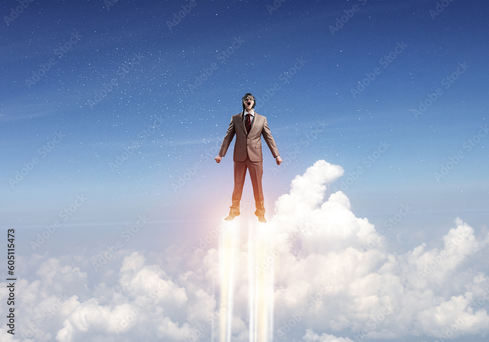 Businessman in suit and aviator hat flying in sky