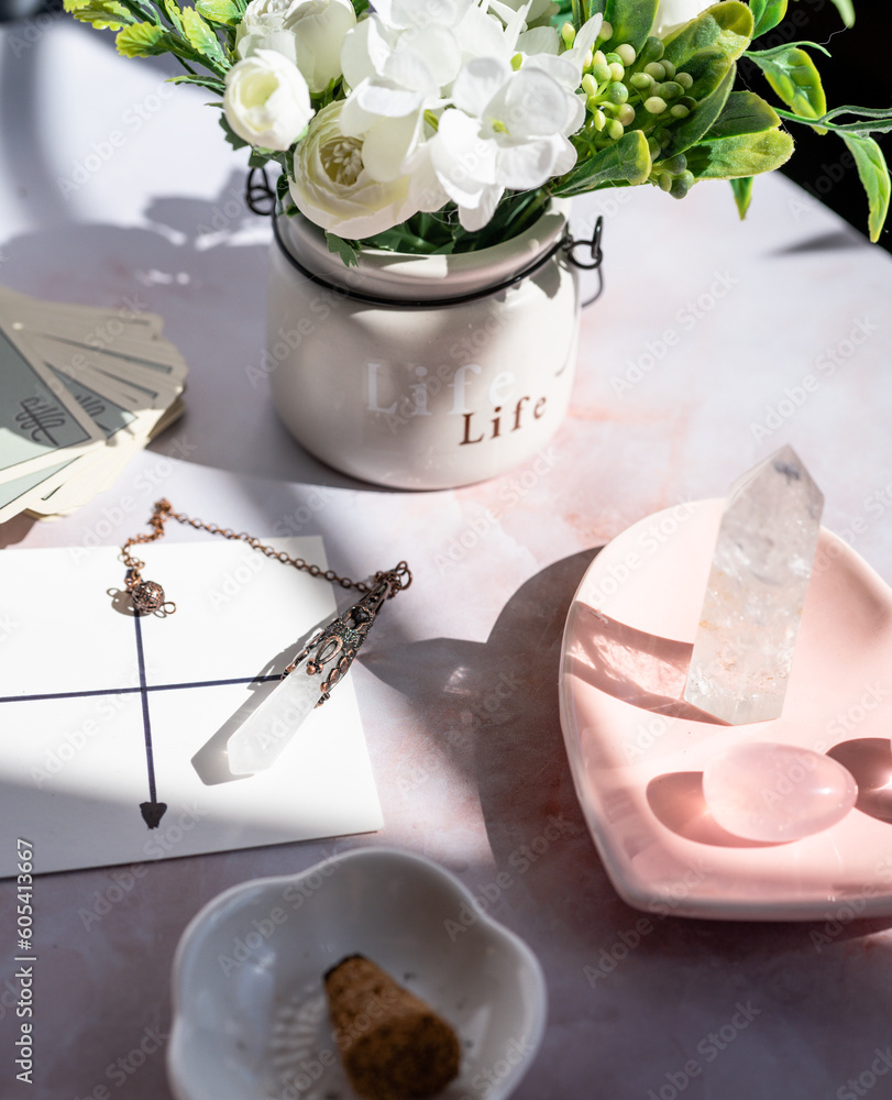 Gemstones for esoteric spiritual practice. Rock crystal pendulum on the table. Divination with a pen