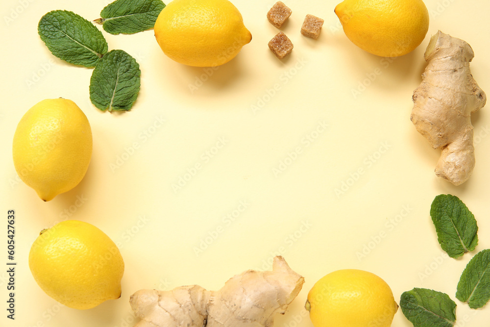 Frame made of ripe lemons with mint and ginger on pale yellow background