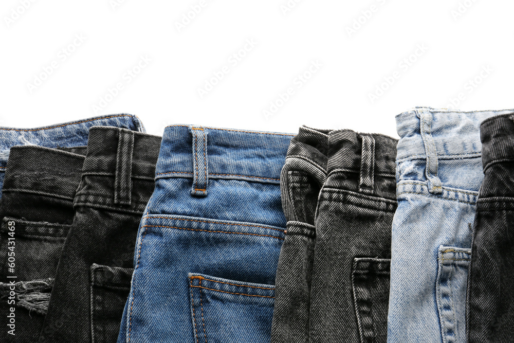 Different stylish denim jeans on white background